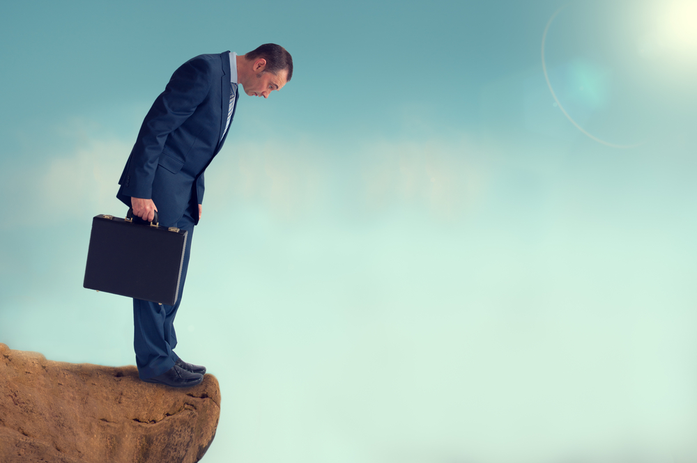 Businessman Looking Over a Cliff