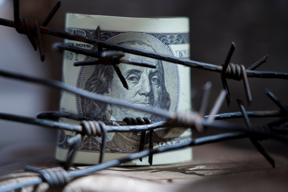 us-dollar-money-wrapped-barbed-wire
