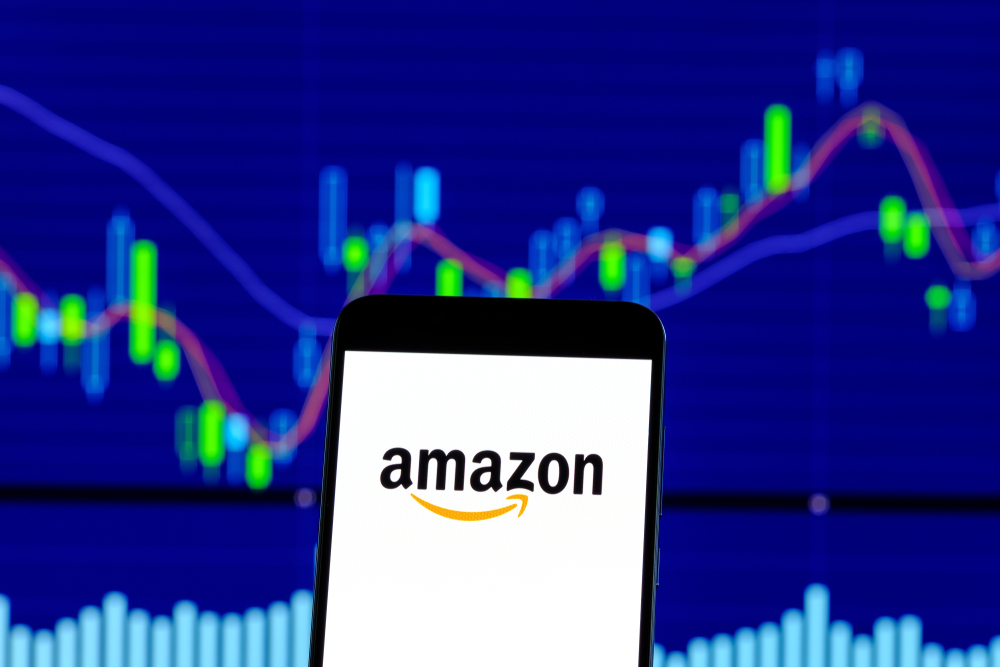 Amazon logo is seen on an smartphone over stock chart