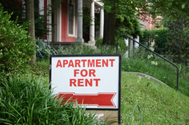 Apartment for rent sign displayed on residental street.
