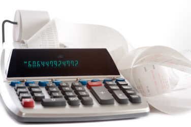 An adding machine or calculator with adding machine tape or paper
