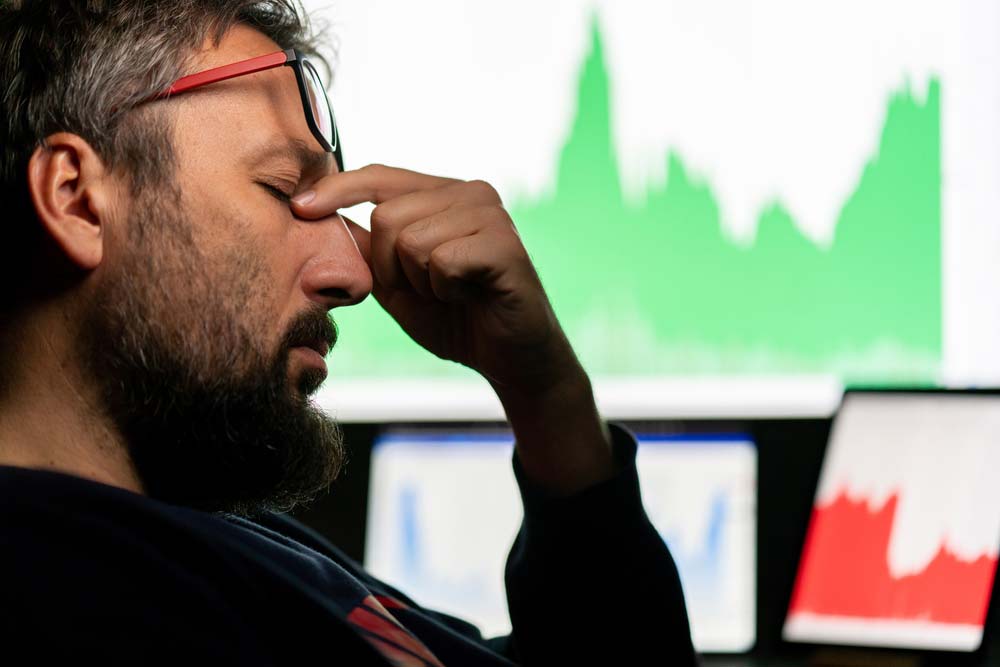Frustrated man looking at stock charts