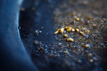 Gold on grungy wash pan with river sand.