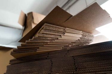 stacks of containerboard sheets in warehouse facility