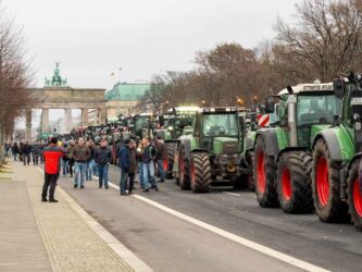 Farm tractors with the Brandenburg Gate in the background.