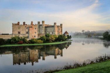 Leeds Castle, Kent, England, at dawn, with mist on the lake.