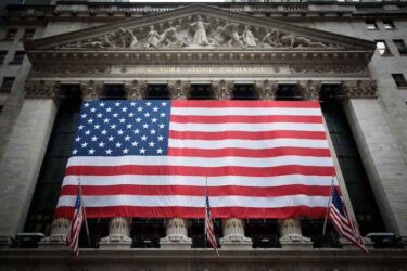 American flag draped over the exterior of the New York Stock Exchange with added vignette.