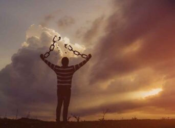 Man with broken chains at the time of the sunrise