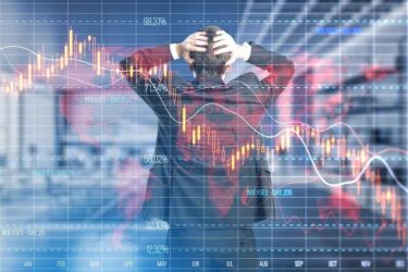 Economy recession and crisis concept with confused trader back view looking at digital falling down red financial chart candlestick and diagram on background