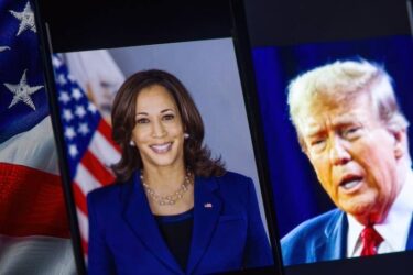 Vice President of the United States Kamala Harris is sharp in the foreground, while republican candidate Donald Trump is blurred in the background