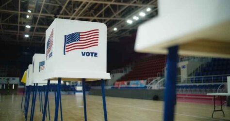 Voting booths with American flag logo at polling station.