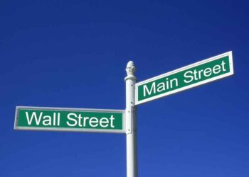 Wall street vs Mainstreet conceptual sign against a clear blue sky