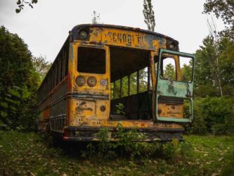 Outside view of the back of an abandoned school bus.