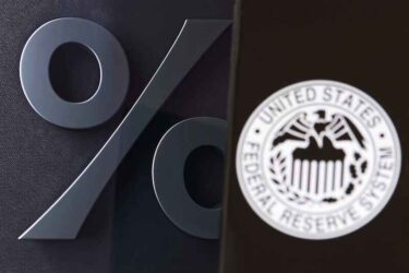 FED sign displayed and blurred on smartphone screen in foreground, percent sign in background, interest rate regulation concept by Central Bank of America, New York, United States