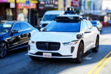 Waymo One Jaguar driverless car on urban street.