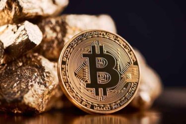 Golden bitcoin next to gold lumps representing futuristic world trends both isolated on black background.