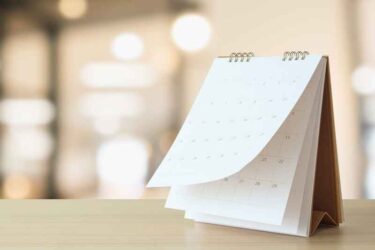 desk calendar on table with blurred bokeh background appointment and business meeting concept.