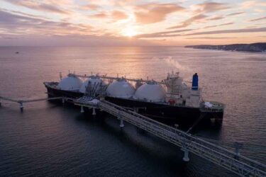 Aerial of Liquified Natural Gas LNG carrier moored to a small gas terminal.