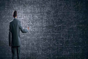 Rear view of businessman looking at business sketch on wall